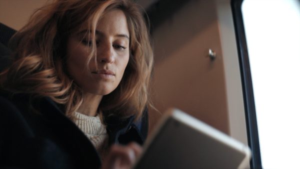 Personen tittar fokuserat ner på läsplatta eller mobil